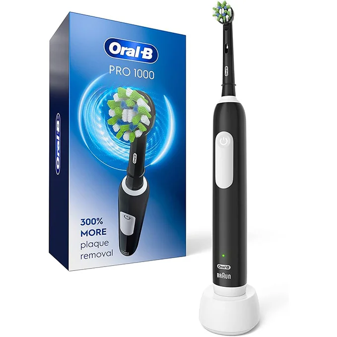 A tube of toothpaste with a self-closing cap is being squeezed onto a toothbrush.